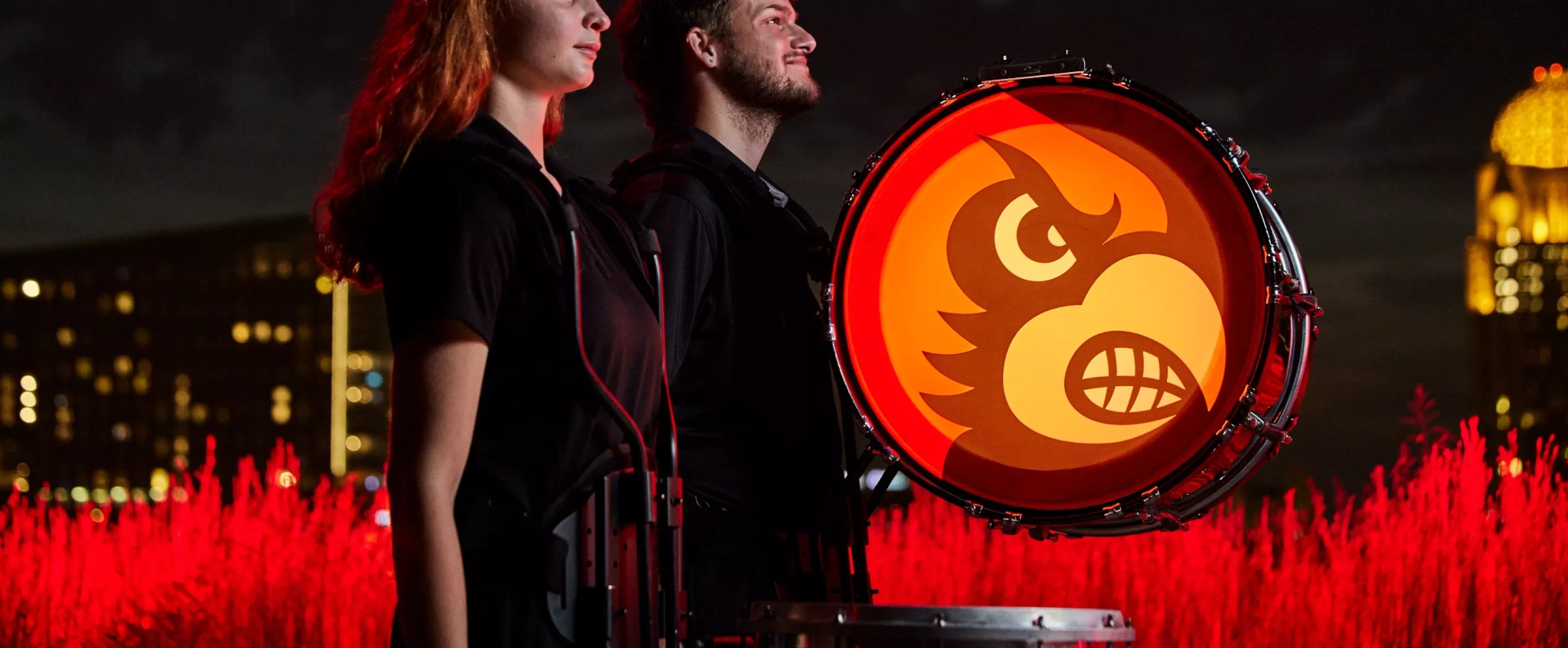 The members are standing side by side as their drums are still and waiting to played.