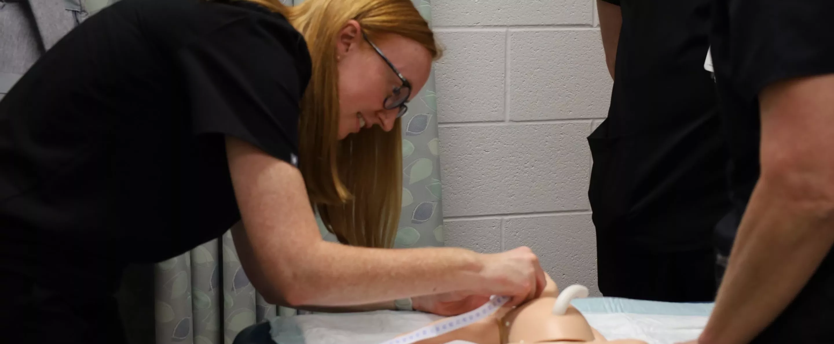 Nursing student performs neonatal simulation.