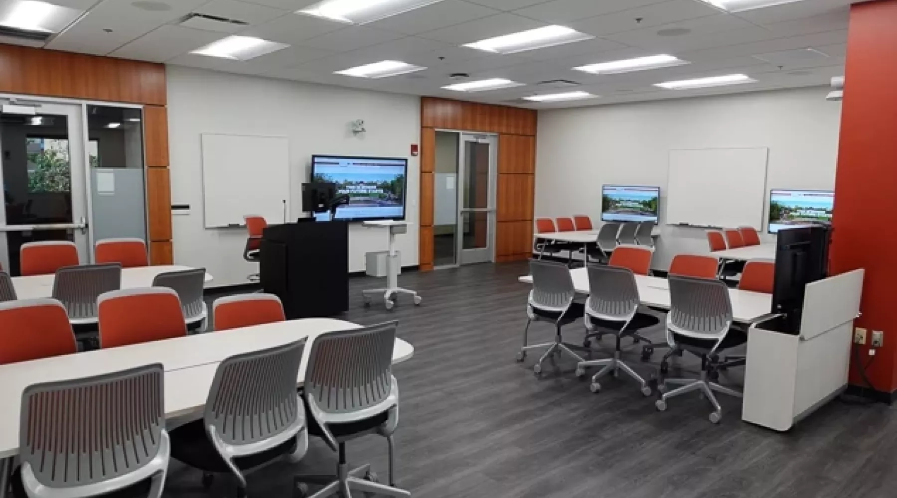 Interactive learning classroom with tables, chairs, and displays.