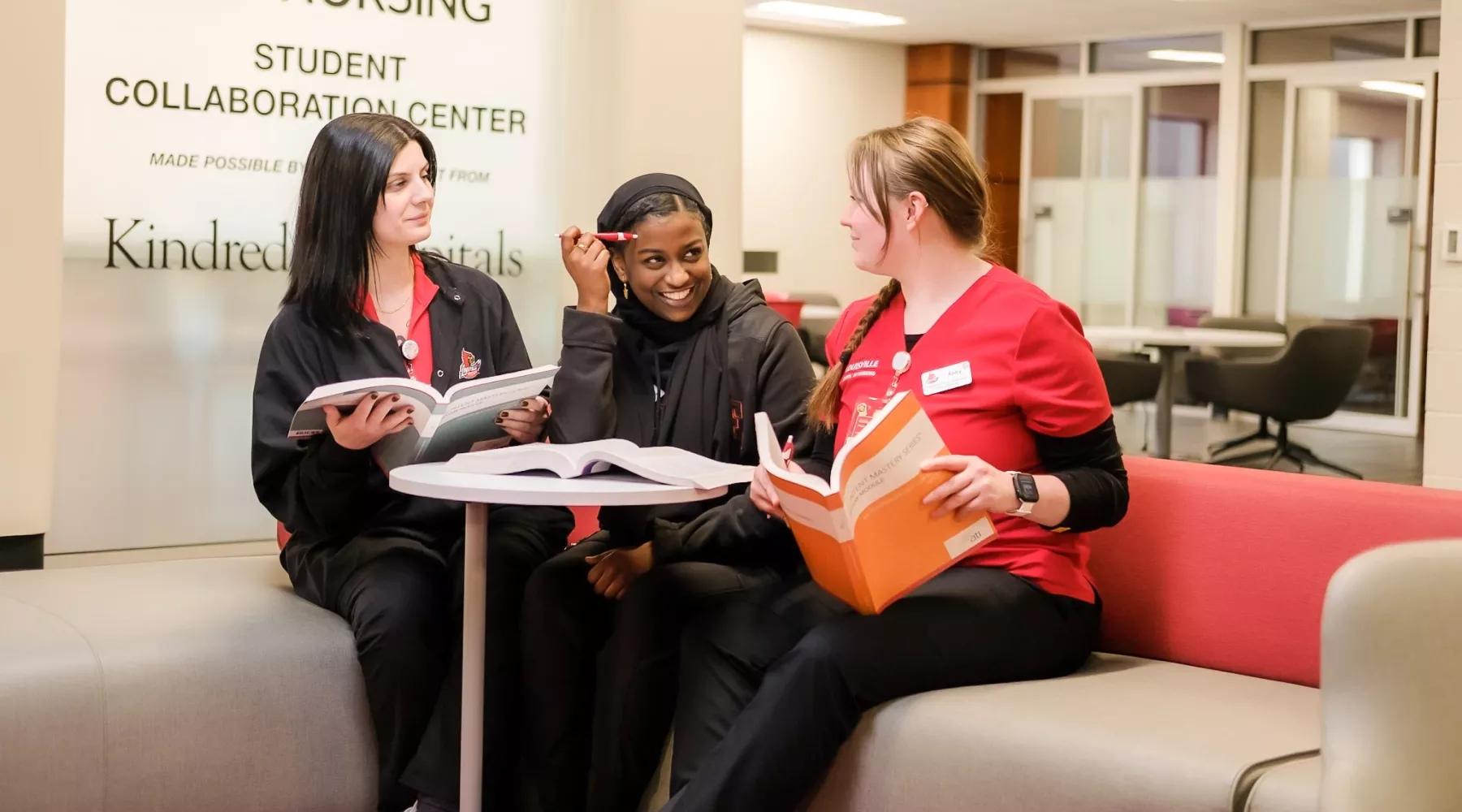 Three BSN students sit together at a small table in the School of Nursing Student Collaboration Center during a study session.
