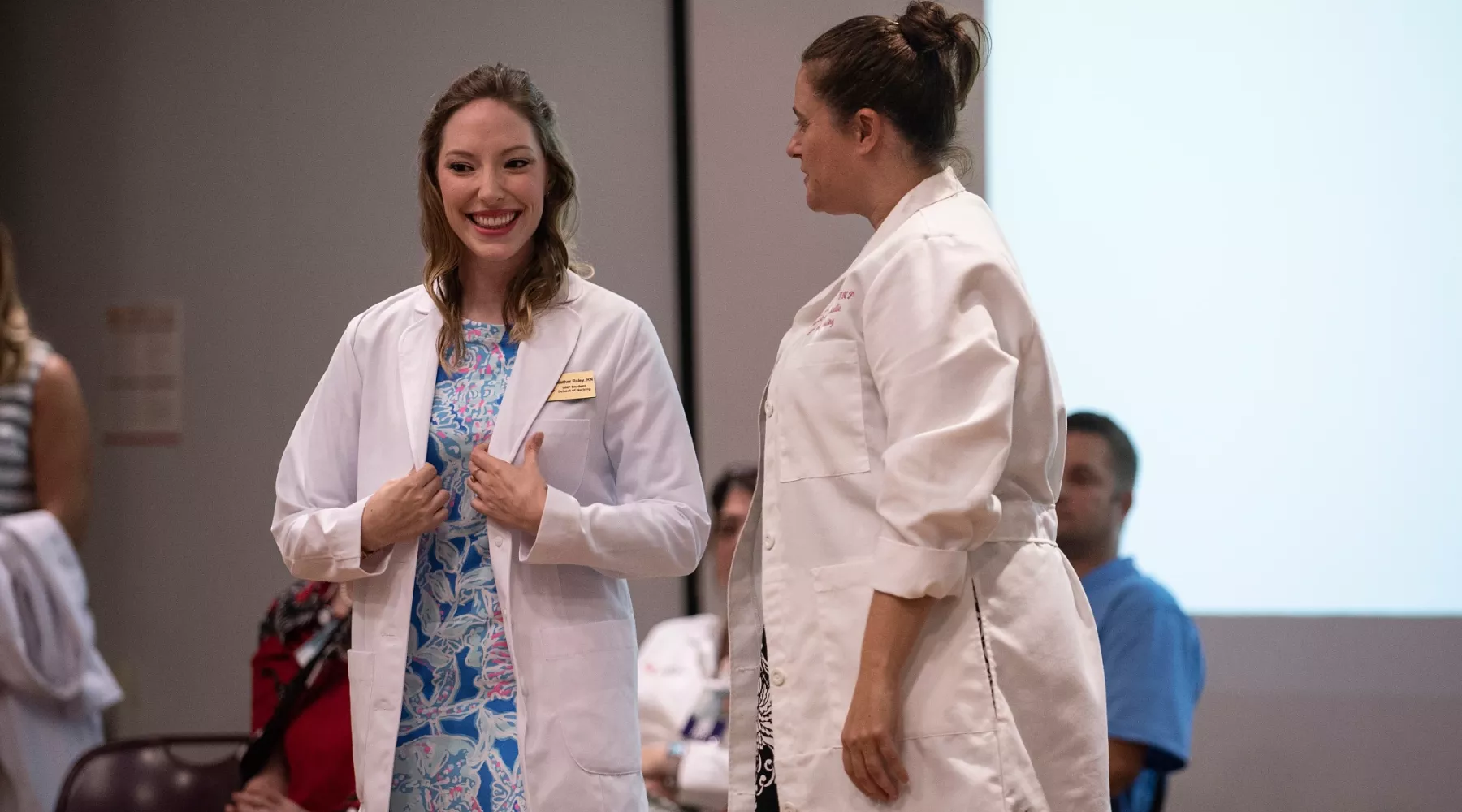 Nursing student putting on white coat