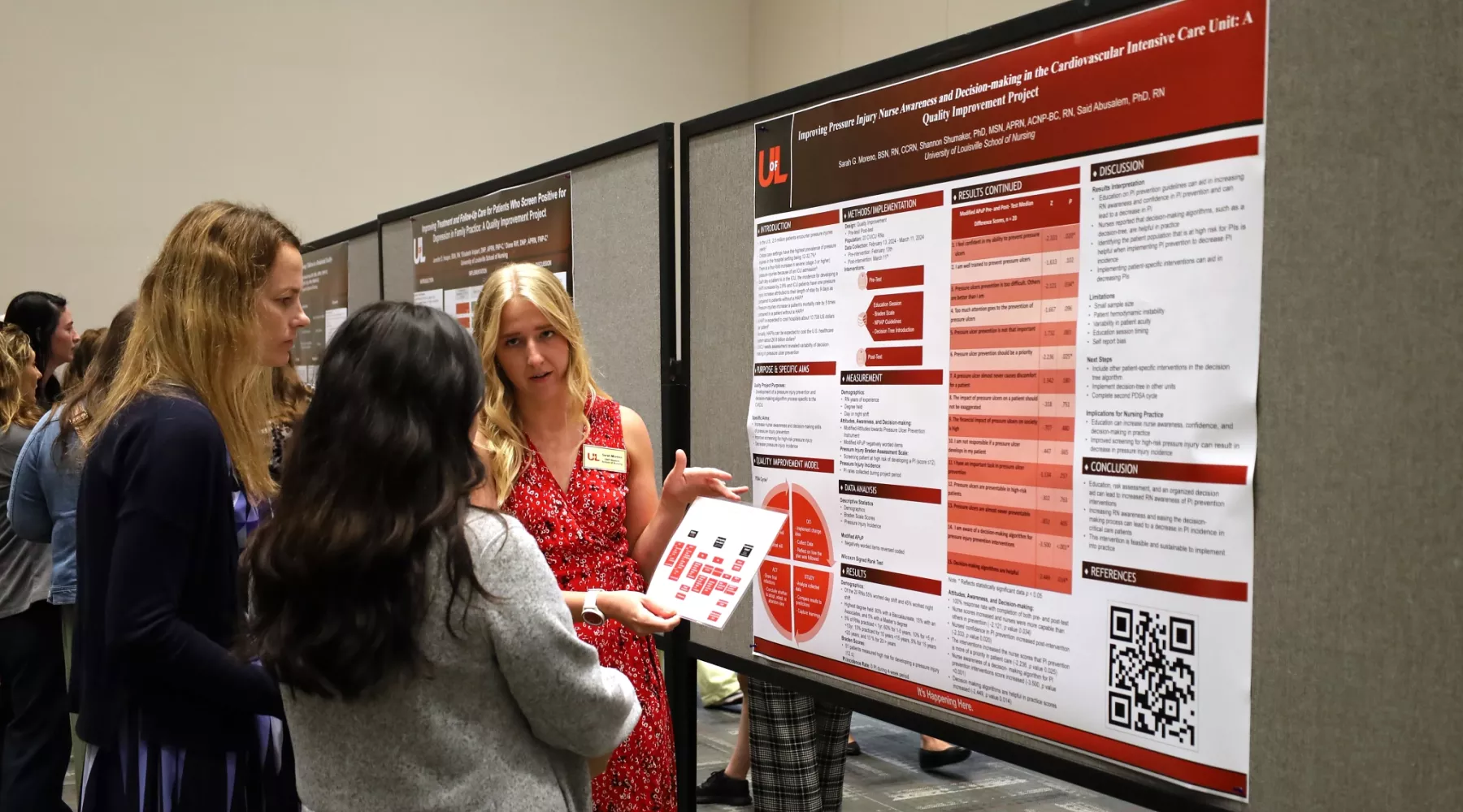 DNP student engaged in poster presentation conversation with two guests.