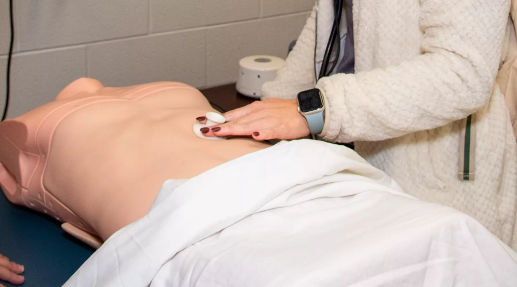 Nursing student performs evaluation on mankin in simulated clinical environment.