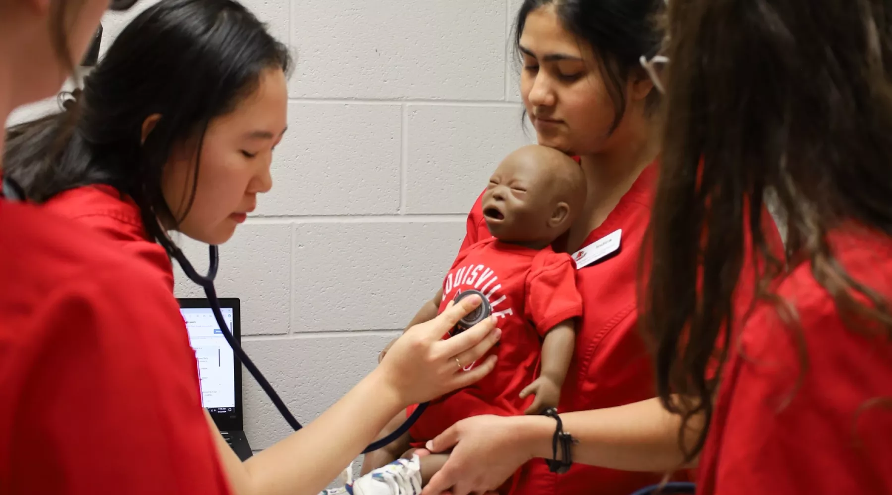 BSN students listen to a manikin during a clinical simulation