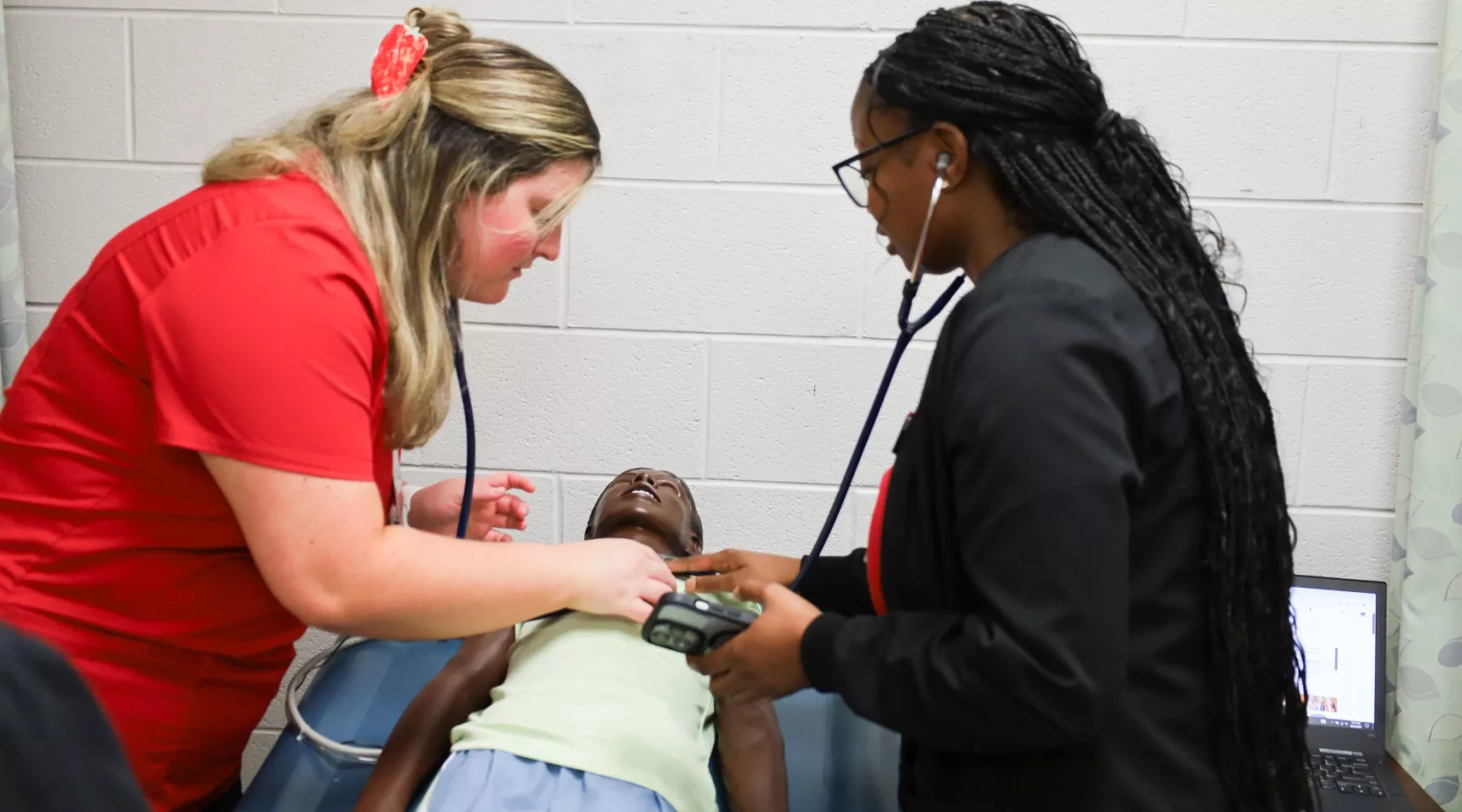 BSN students performing clinical simulation with toddler manikin.