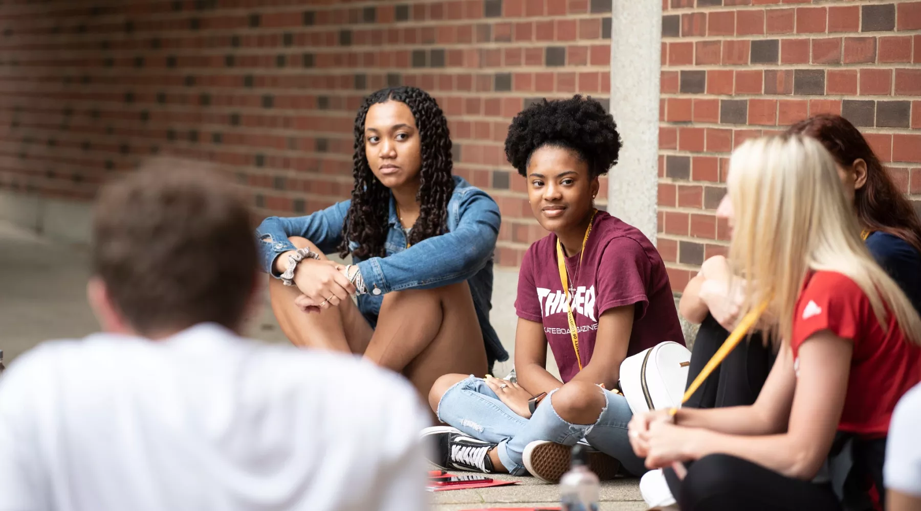 Students sit in a circle and listen to the orientation leader at the 2019 summer orientation.