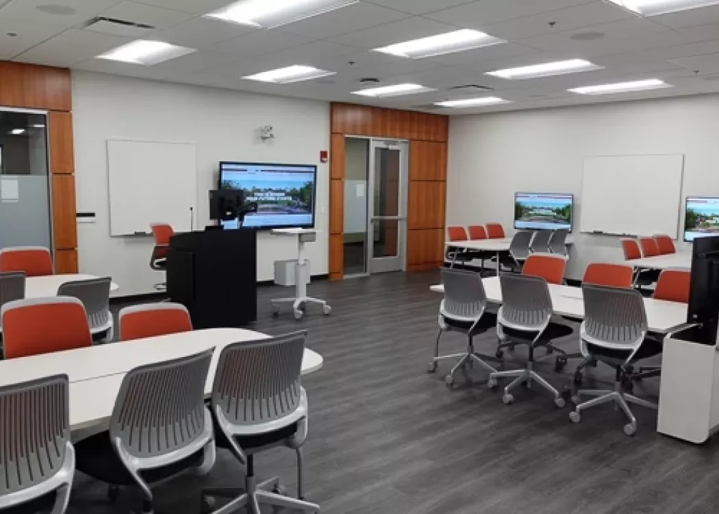 Interactive learning classroom with tables, chairs, and displays.