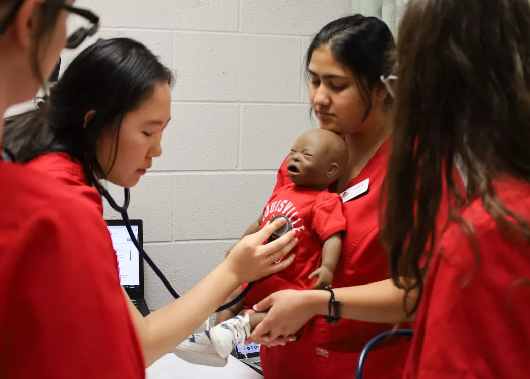 BSN students listen to a manikin during a clinical simulation