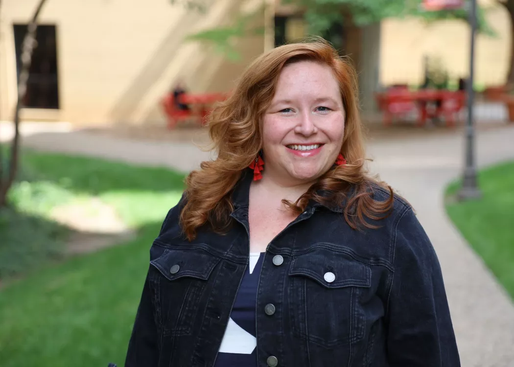 University of Louisville School of Nursing Academic advisor, Lauren McCurdy, standing outside the School of Nursing building on a sunny day, smiling at the camera.